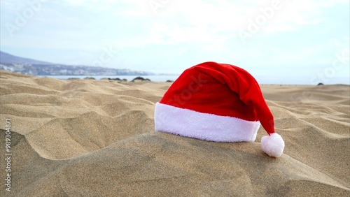 Merry Christmas from the Canary Islands. Santa's hat on the sand of the Maspalomas dunes. Travel and holidays in warm climate concepts