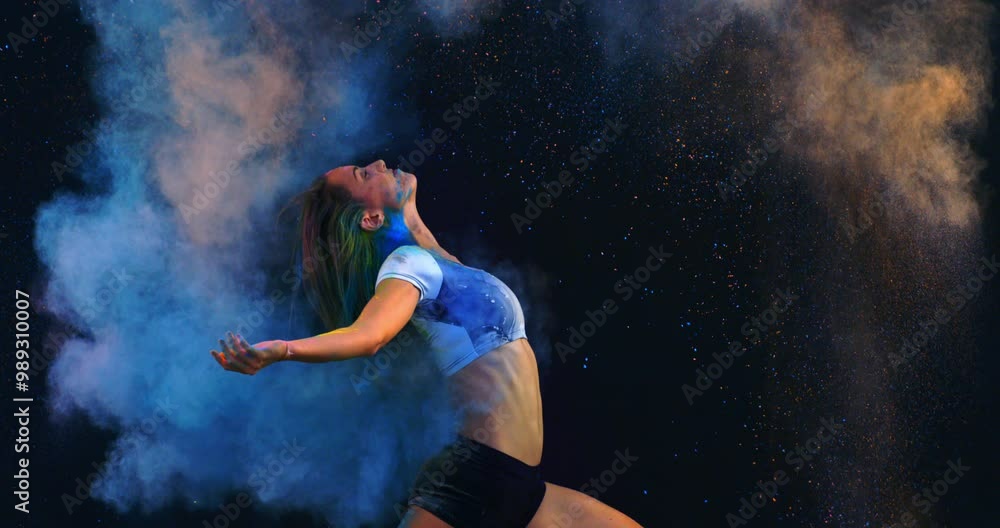 Super slow motion close up of female classical dancer or acrobatic athlete waving with hair in colorful rainbow colors holi powder splash at 1000 fps.