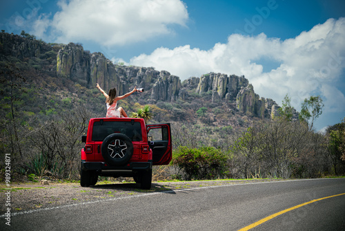 Road trip in a red jeep, girl having fun.