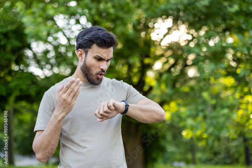 Canvas Print Close-up photo of a shocked and disappointed young Indian man looking at the sma