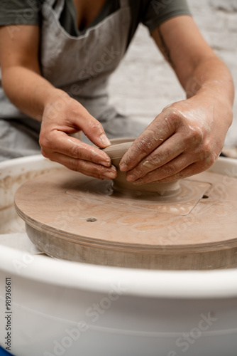 Creating a ceramic bowl by yourself in a pottery class. Wheel throwing. Learning how to model clay into different shapes with pottery wheel.