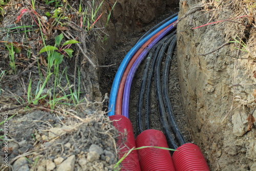 Cables and pipes in the ground on construction site. Electrical cables in the ground next to the train tracks
