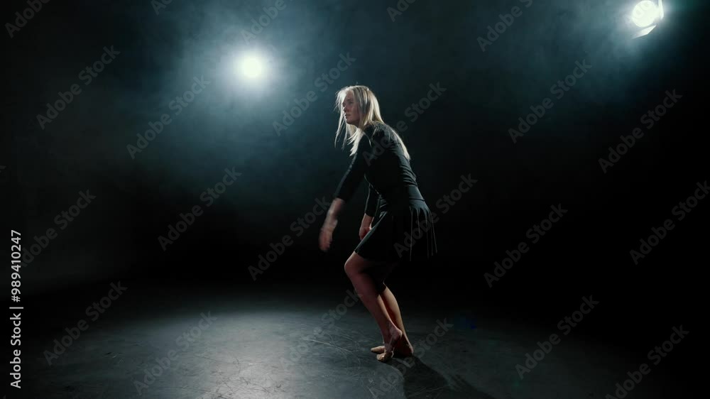 Modern ballerina dancing in darkness, graceful lady jumping, slow motion. Talented female dancer rehearsing contemporary choreography in dark dance class, silhouette of pretty slender lady in black Modern ballerina dancing in darkness, graceful lady jumping, slow motion. Talented female dancer rehearsing contemporary choreography in dark dance class, silhouette of pretty slender lady in black