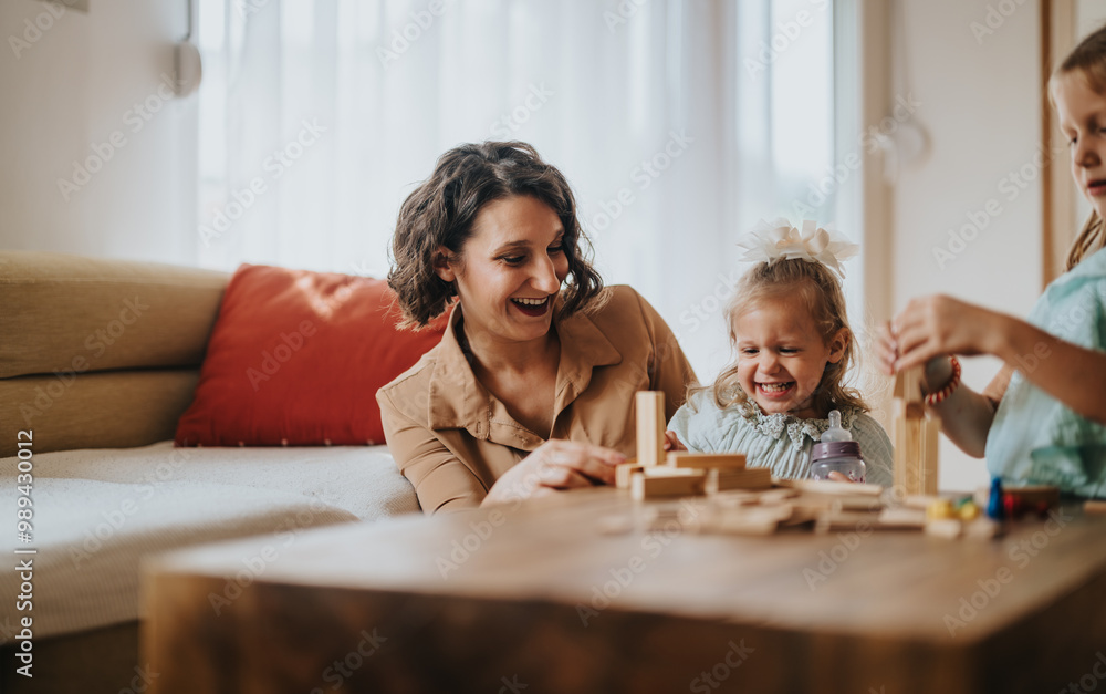 A joyful mother and her two daughters playing and laughing with wooden blocks at home. The image captures a warm and loving family moment filled with happiness. A joyful mother and her two daughters playing and laughing with wooden blocks at home. The image captures a warm and loving family moment filled with happiness.
