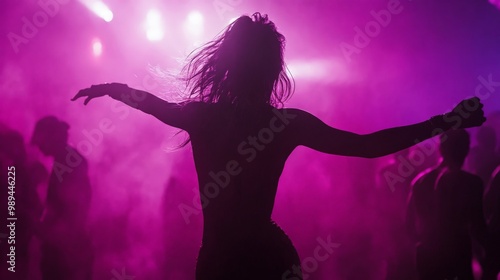 A silhouette of a woman dancing in front of a crowd of people.