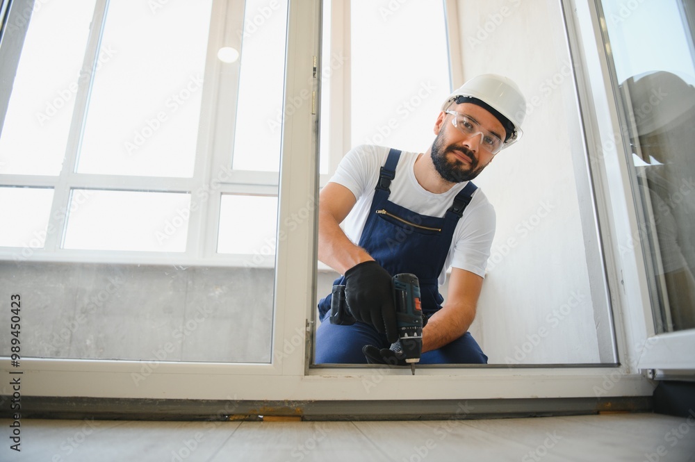 handyman adjusting white pvc plastic window indoors. worker using screwdriver to repair upvc window. homework maintenance handyman adjusting white pvc plastic window indoors. worker using screwdriver to repair upvc window. homework maintenance