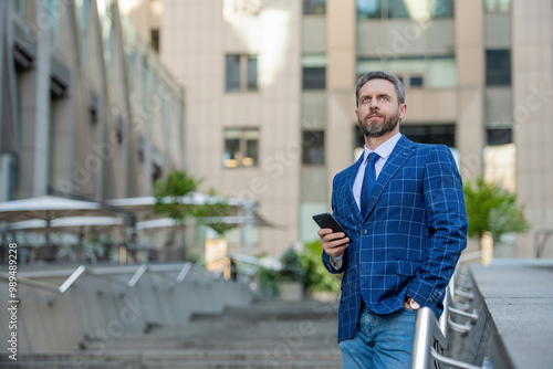 Businessman using phone. Man phone conversation in city. Businessman talking on phone. Businessman in front office. Social network. Hispanic business man with phone at office building. Copy space