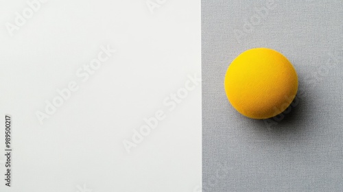 Yellow fabric ball and gray cardboard on a flat white background Modern color scheme with ample copy space available