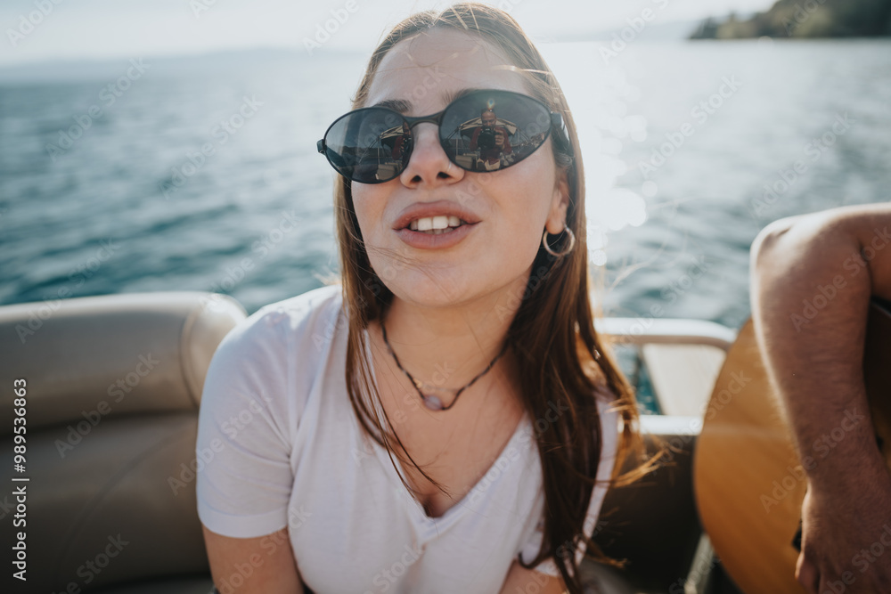 A joyful young woman in sunglasses enjoys a relaxing boat ride on a sunny day, showcasing happiness and leisure by the sea. A joyful young woman in sunglasses enjoys a relaxing boat ride on a sunny day, showcasing happiness and leisure by the sea.