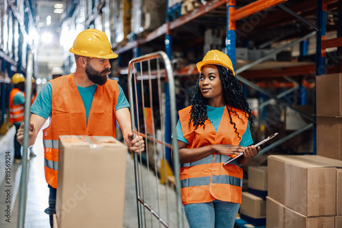 Diverse ollaborative warehouse workers reviewing logistics on clipboard photo