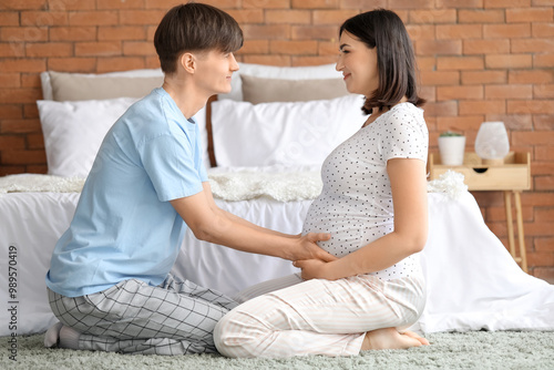 Young pregnant couple sitti...