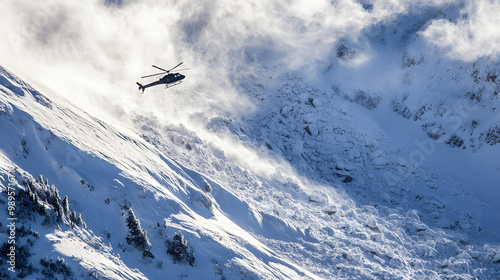 Obraz na płótnie A helicopter flying above a recent avalanche surveying the damage as massive snowdrifts and debris cover the mountainside. w salonie