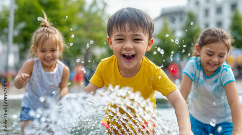 A group of children play joyfully in a water fountain, splashing water and sharing laughter on a sunny afternoon
