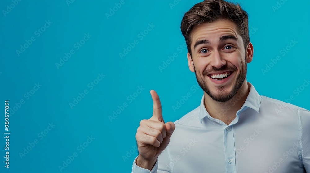 Portrait of cheerful businessman pointing at copy space for advertising against blue background. Portrait of cheerful businessman pointing at copy space for advertising against blue background.