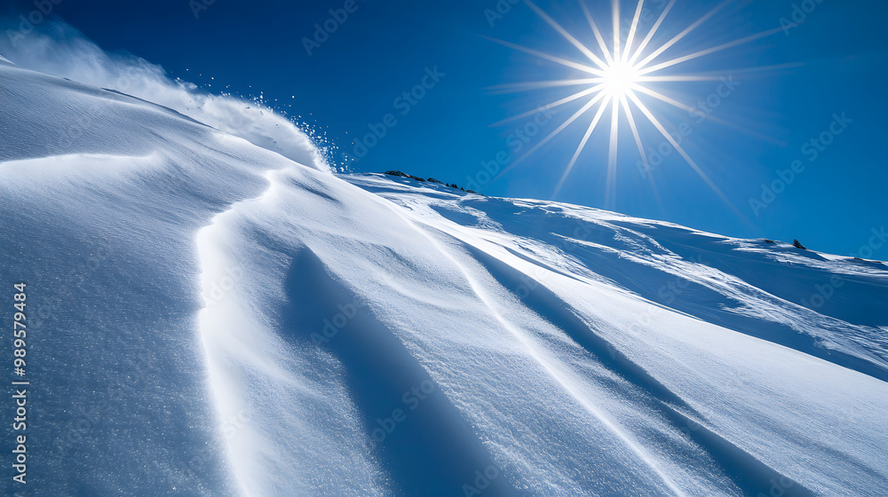 A snowboarder dropping into a steep bowl the sun shining brightly overhead casting long shadows on the snow.