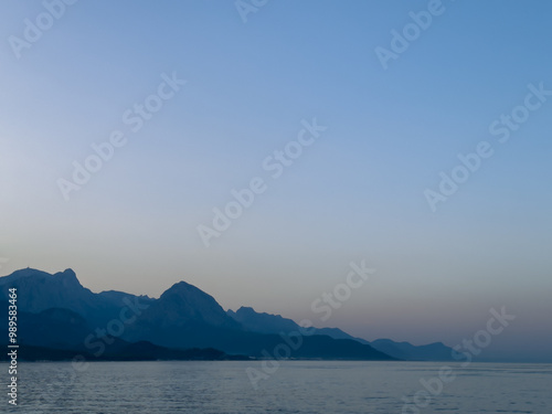 Incredibly beautiful sea sunset against the backdrop of mountains and calm water. Very beautiful color of the sky,