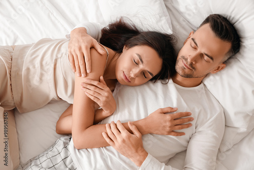 Young couple sleeping in be...