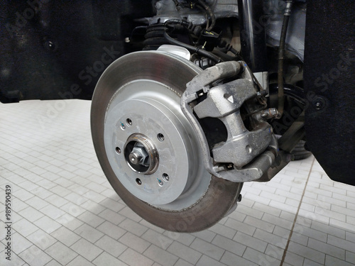 A close-up view of a brake disc and brake caliper installed on a modern car.