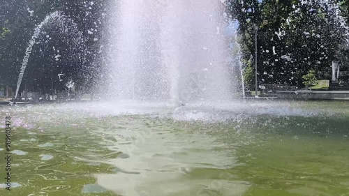 stunning fountain in a quiet city park, surrounded by flowering plants  photo