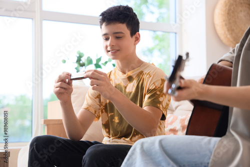 Teenage boy with harmonica ...
