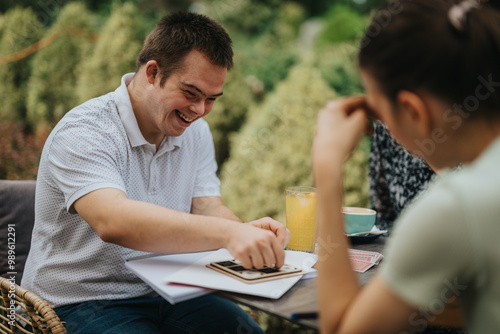 A joyful group of friends playing a game at a cafe, sharing laughter and leisure time, surrounded by nature. Ideal for concepts of friendship and relaxation.