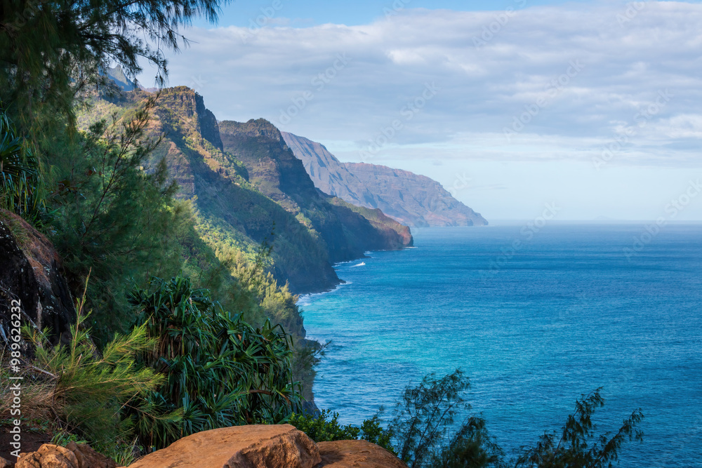 Scenic view of amazing Napali Coast seen from Kalalau Trail, Kauai, Hawaii, USA against blue sky with clouds in the morning