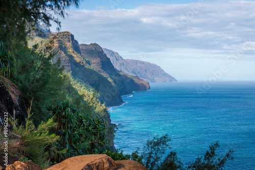 Obraz na płótnie Scenic view of amazing Napali Coast seen from Kalalau Trail, Kauai, Hawaii, USA against blue sky with clouds in the morning w salonie