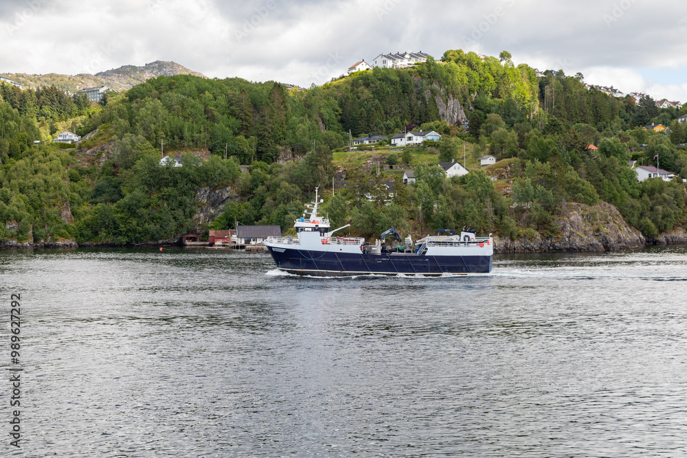 A Passenger Ferry Boat Passing By a Wooded Residential Area on the Fjord Leaving Bergen Norway A Passenger Ferry Boat Passing By a Wooded Residential Area on the Fjord Leaving Bergen Norway