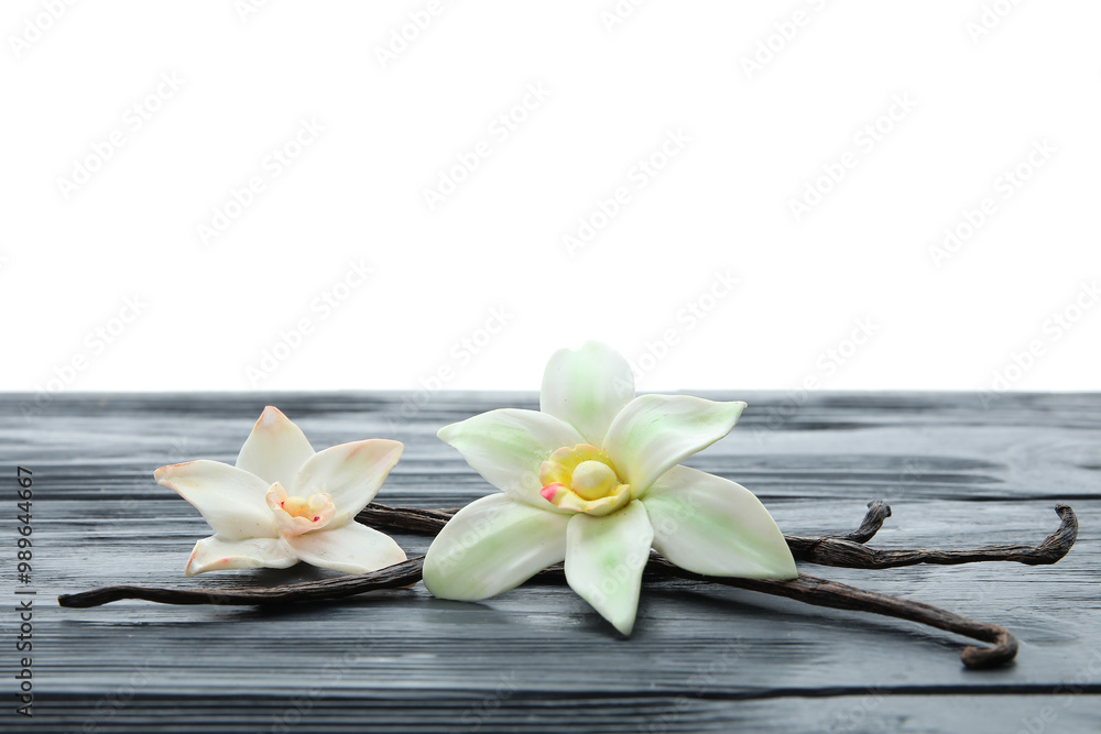 Aromatic vanilla pods and flowers on table against white background Aromatic vanilla pods and flowers on table against white background