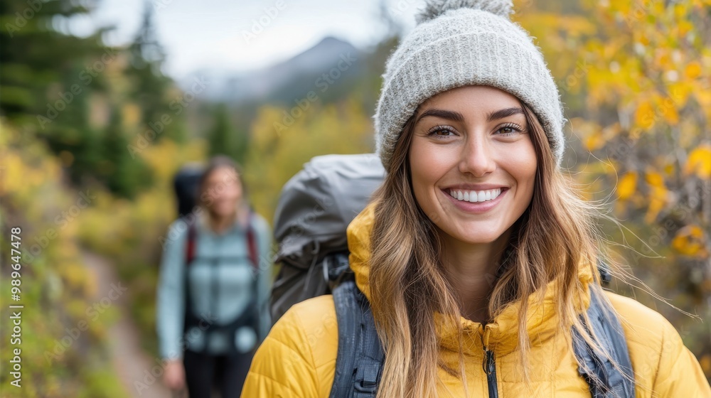 A smiling woman in a yellow jacket and grey beanie enjoys a hike among vibrant autumn trees, capturing the essence of joy and connection with nature. A smiling woman in a yellow jacket and grey beanie enjoys a hike among vibrant autumn trees, capturing the essence of joy and connection with nature.