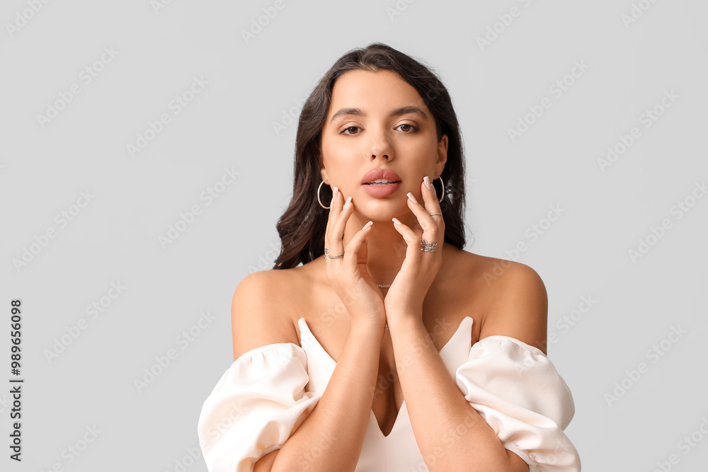 Fashionable young woman in beautiful jewelry on grey background Fashionable young woman in beautiful jewelry on grey background