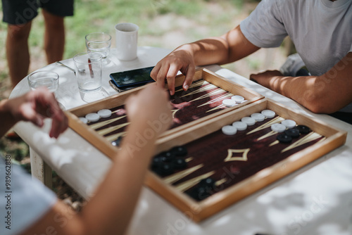 Fotografia A group of friends playing backgammon on a sunny day, creating a relaxed and fun atmosphere