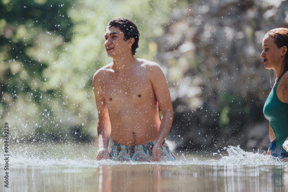 A young man and woman enjoying a swim in a natural setting on a sunny day, capturing the essence of summer fun and relaxation. A young man and woman enjoying a swim in a natural setting on a sunny day, capturing the essence of summer fun and relaxation.