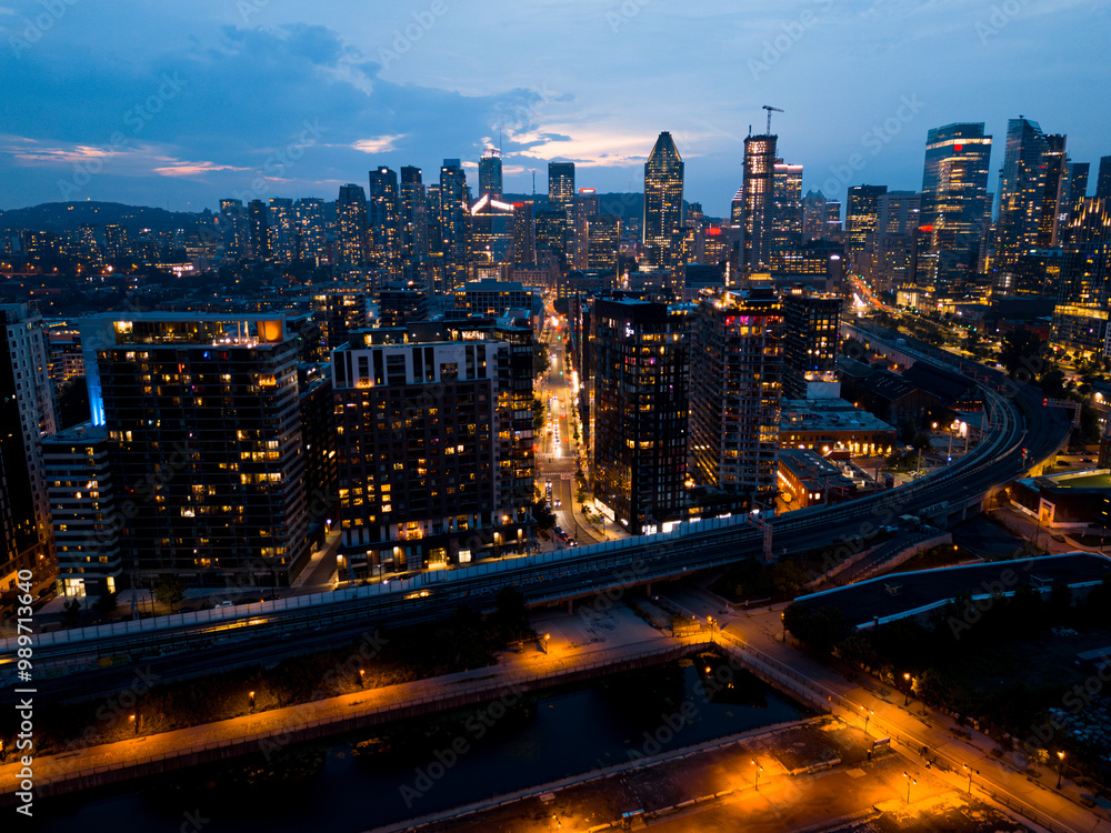 Fototapeta premium Montreal skyline illuminated at dusk and reflected in the water, Quebec, Canada