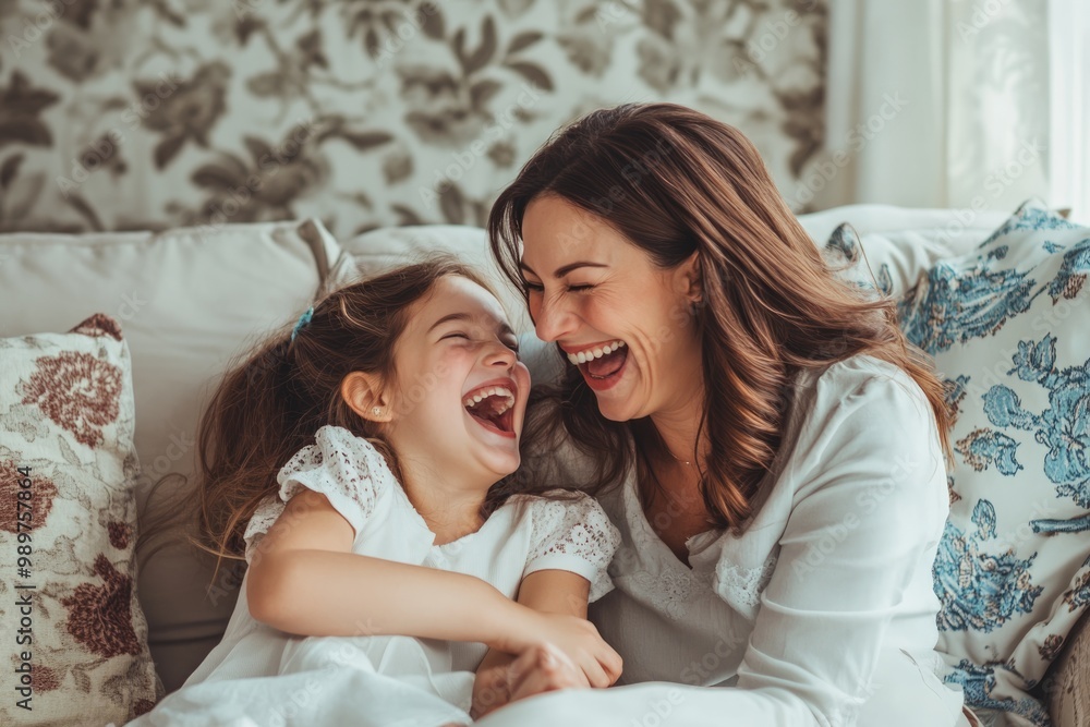 High-resolution brightly lit photorealistic candid photograph of a mother and daughter laughing together on a comfy couch in a beautifully decorated living room. The photo has a light and bright High-resolution brightly lit photorealistic candid photograph of a mother and daughter laughing together on a comfy couch in a beautifully decorated living room. The photo has a light and bright