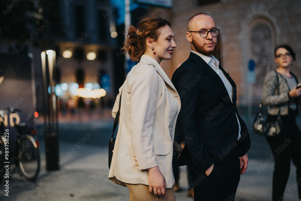 Fototapeta premium Business professionals walking confidently in the city at night, showcasing an urban lifestyle and blurred city lights.