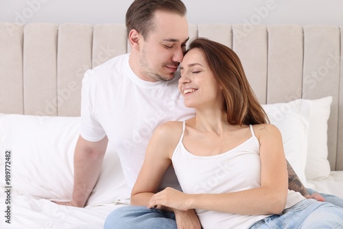 Happy couple spending time together on bed at home