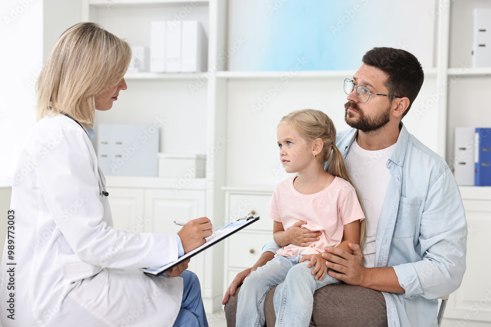Fototapeta premium Doctor consulting little girl with stomach pain and her father in hospital