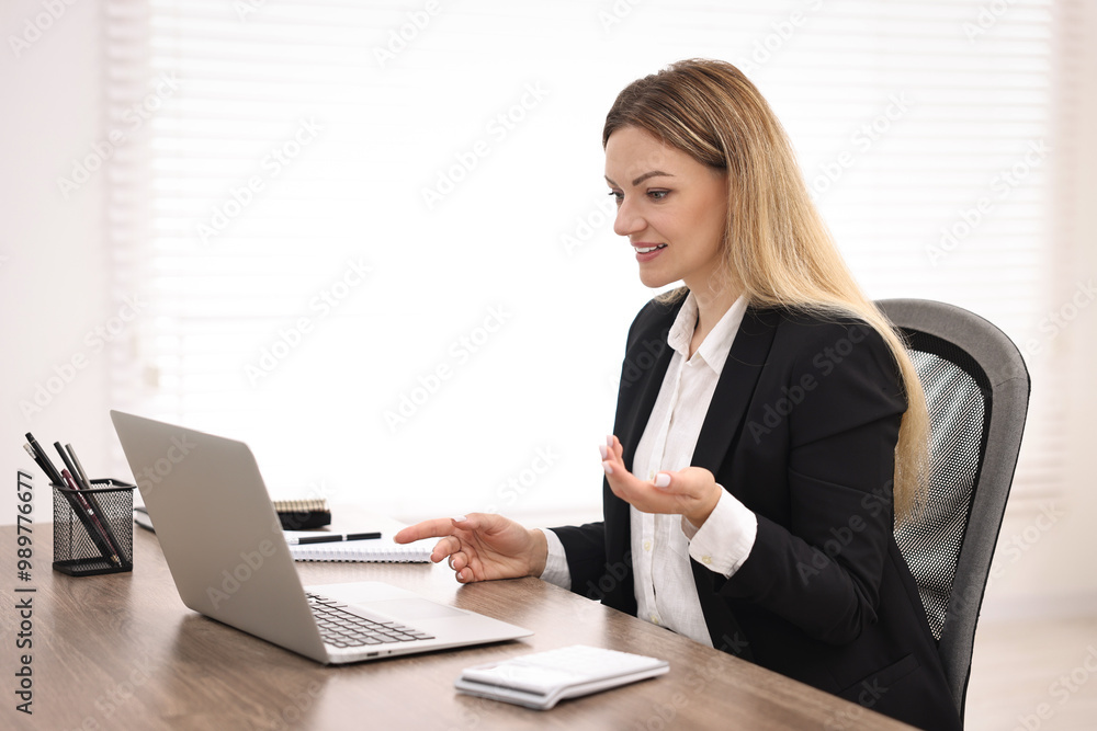 Banker with laptop working at table in office Banker with laptop working at table in office