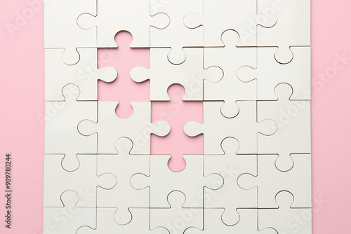 White puzzle with missing pieces on pink background, top view