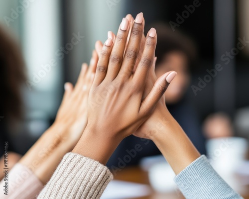 A boardroom filled with excited team members high-fiving after a successful funding pitch