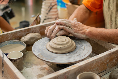 Close up of a potter's hands creating a ceramic vase on the craft wheel. photo