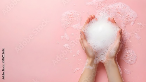 Obraz na płótnie Close-up of hands washing with minimal soap and white foam against a soft pastel pink background. Clean, hygienic, and focused on personal care with copy space for text.
w salonie