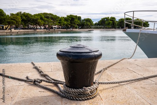 Φωτογραφία Close-up of a bollard with many ship ropes wrapped around it in the port of the