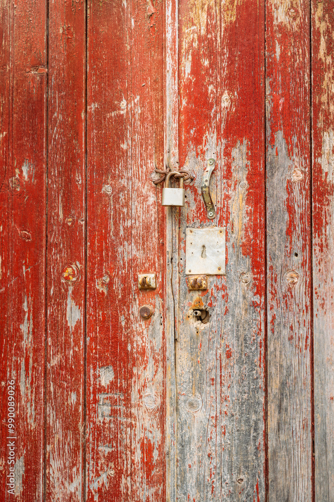 Abstract, Rustic, flaking, peeling red paint on a rotting and decaying door with rusty lock and keyhole at an abandoned house’s doorway Abstract, Rustic, flaking, peeling red paint on a rotting and decaying door with rusty lock and keyhole at an abandoned house’s doorway