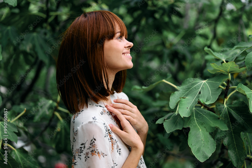 happy woman standing in front of a flourishing tree with leaves on its branches happy woman standing in front of a flourishing tree with leaves on its branches