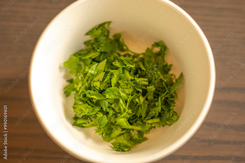 Chopped Parsley in a Small White Bowl Close-Up Chopped Parsley in a Small White Bowl Close-Up
