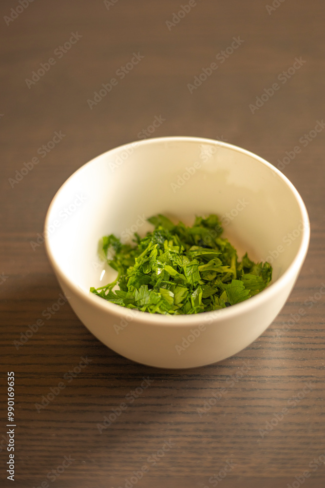 Chopped Parsley in a Small White Bowl Close-Up Chopped Parsley in a Small White Bowl Close-Up