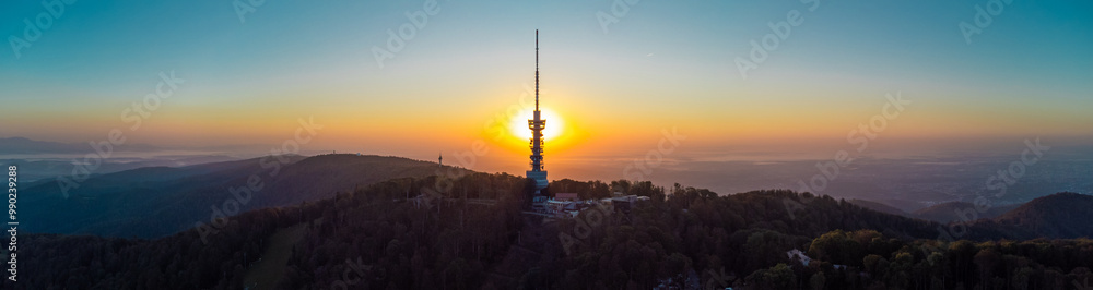 Obraz premium Early morning sunrise panorama of Sljeme above Zagreb with visible antenna tower, big massive hill and layers of fog below in valley. Epic panorama above zagreb