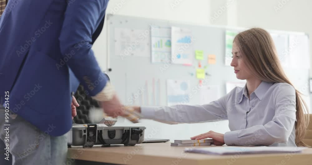 Businessman gives bribe to government lady manager putting money in case at table. Woman fills briefcase with cash meeting colleague in office Businessman gives bribe to government lady manager putting money in case at table. Woman fills briefcase with cash meeting colleague in office